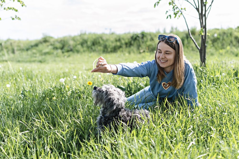 Woman playing with her doggie in a field. Things that matter less after fifty...working too much.
